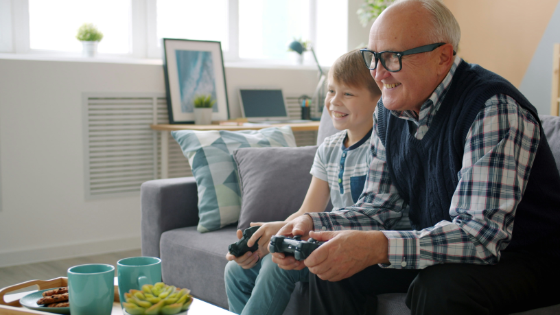 Grand-père jouant à la console avec son petit-fils (photo Vitaly Gariev/Unsplash).