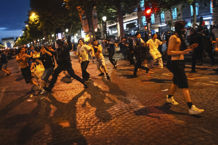 Policiers dispersant la foule sur l'avenue des Champs-Élysées, après la victoire du PSG en Ligue des Champions, le 30 mai 2026 (photo Nael Chahine/Middle East Images/AFP).