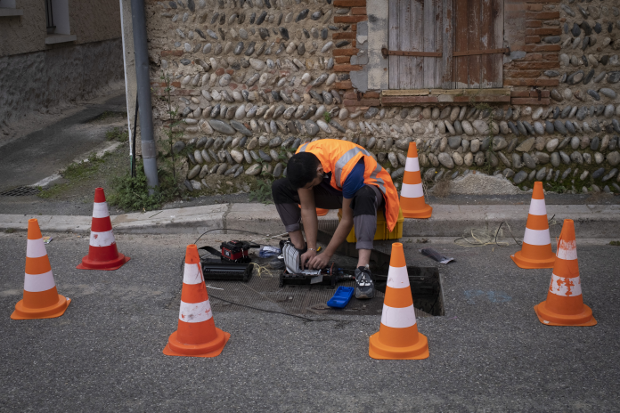 Un homme installe la fibre optique et se connecte au réseau (photo Arnaud Chochon/Hans Lucas/AFP).