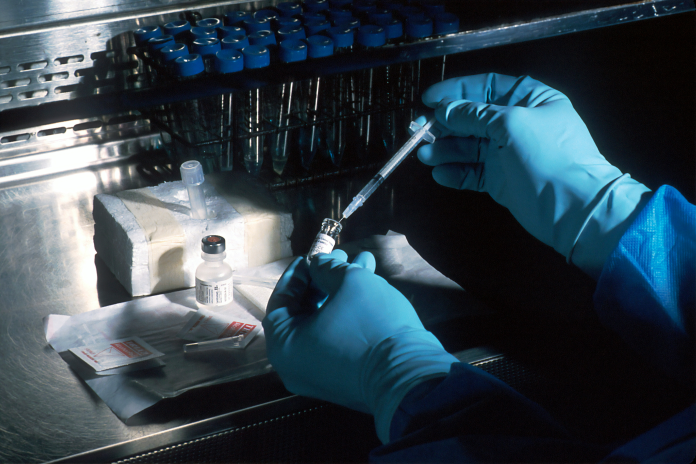 Prélèvement d'un produit en laboratoire à l'aide d'une seringue (photo National Cancer Institute/Unsplash).