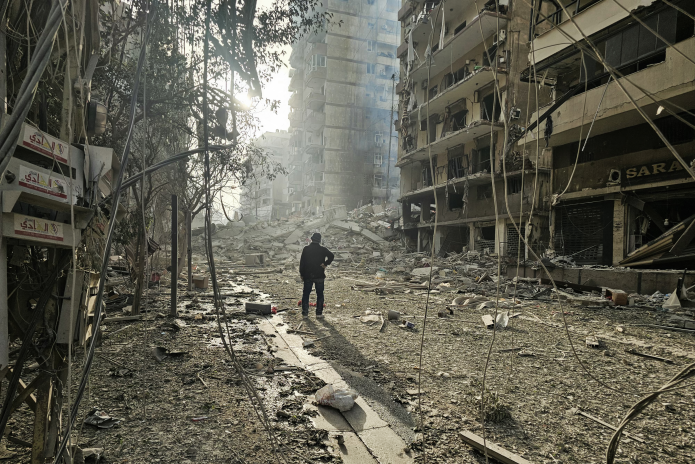 Un homme observant le site de frappes aériennes israéliennes nocturnes dans la banlieue sud de Beyrouth, le 12 mars 2026 (photo AFP).