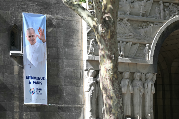 Affiche sur une église pour la venue du Pape Leon XIV à Paris (photo Lou Benoist/AFP).
