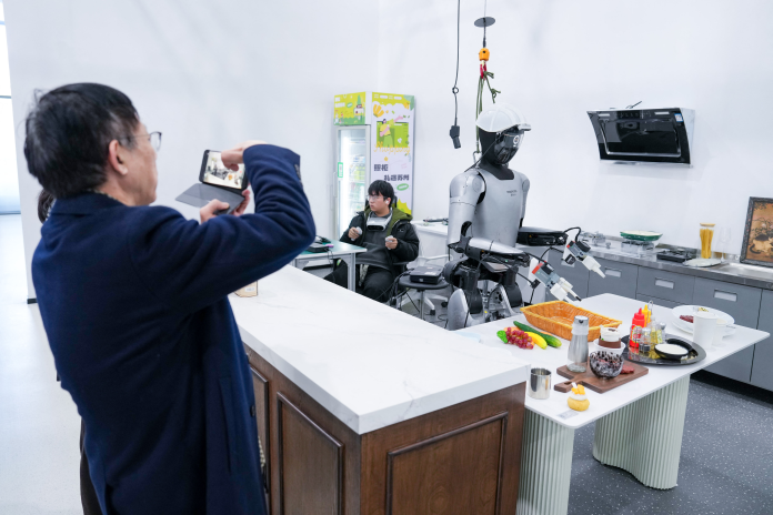 Robot humanoïde répétant différents scénarios d'activités de la vie quotidienne, dans un centre d'entraînement pour robots, au sein du Suzhou Embodied Artificial Intelligence Robotics Innovation Center, à Suzhou, en Chine (Photo Li Bo/Xinhua/AFP).