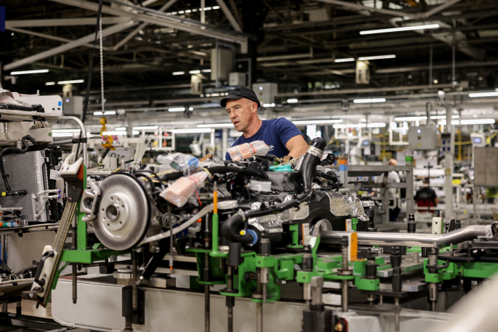 Un employé travaille sur la ligne de production de la nouvelle voiture électrique Peugeot e-3008 le 12 septembre 2023 à l'usine Stellantis à Sochaux, France. (Photo ARNAUD FINISTRE / AFP)