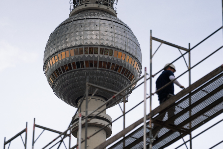Un ouvrier sur un échafaudage à Alexanderplatz, où Covivio construit un gratte-ciel. La tour de télévision apparaît en arrière-plan (Photo by Hauke Schröder / DPA / dpa Picture-Alliance via AFP)