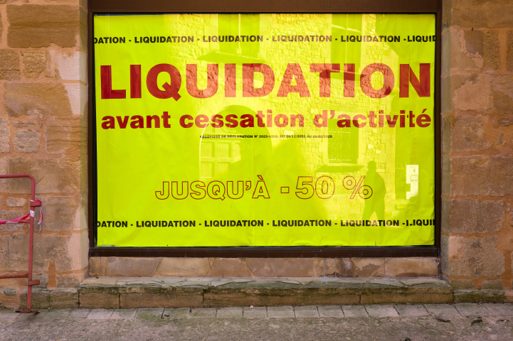France, Sarlat, 20/03/2026. Une vitrine affiche une grande banderole jaune annonçant une vente de liquidation avant la fermeture de l'entreprise. (Photo de Mathieu Thomasset/Hans Lucas/Hans Lucas via AFP)